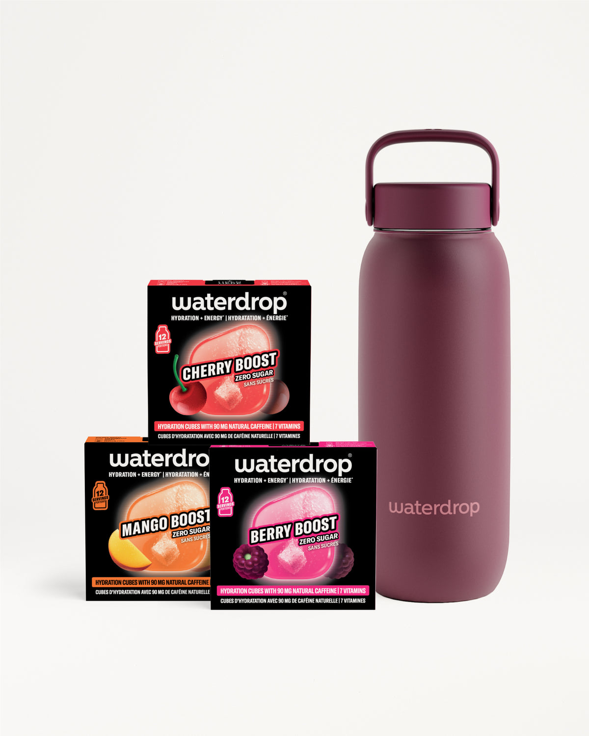 Bouteille d'eau isolante magenta avec poignée à côté de trois petites boîtes noires.