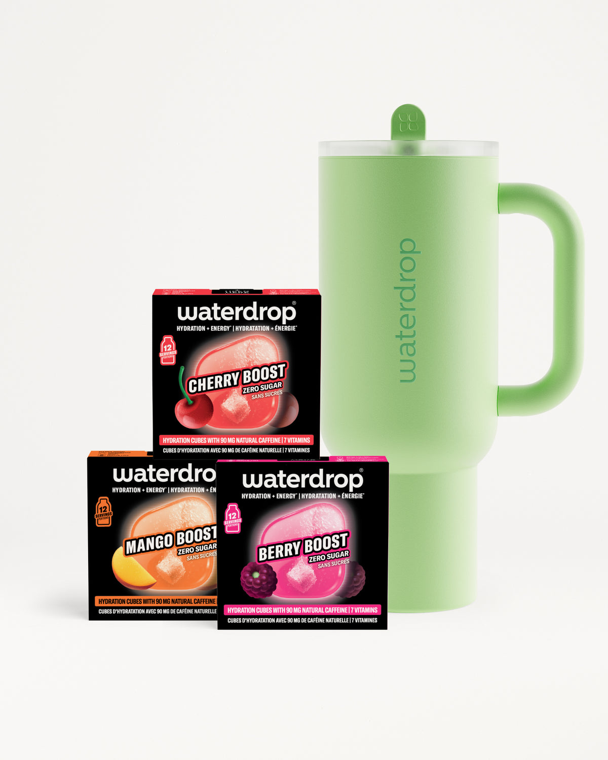 Trois boîtes booster de saveur orange, rose et violette à côté d'une tasse isotherme vert clair avec poignée.