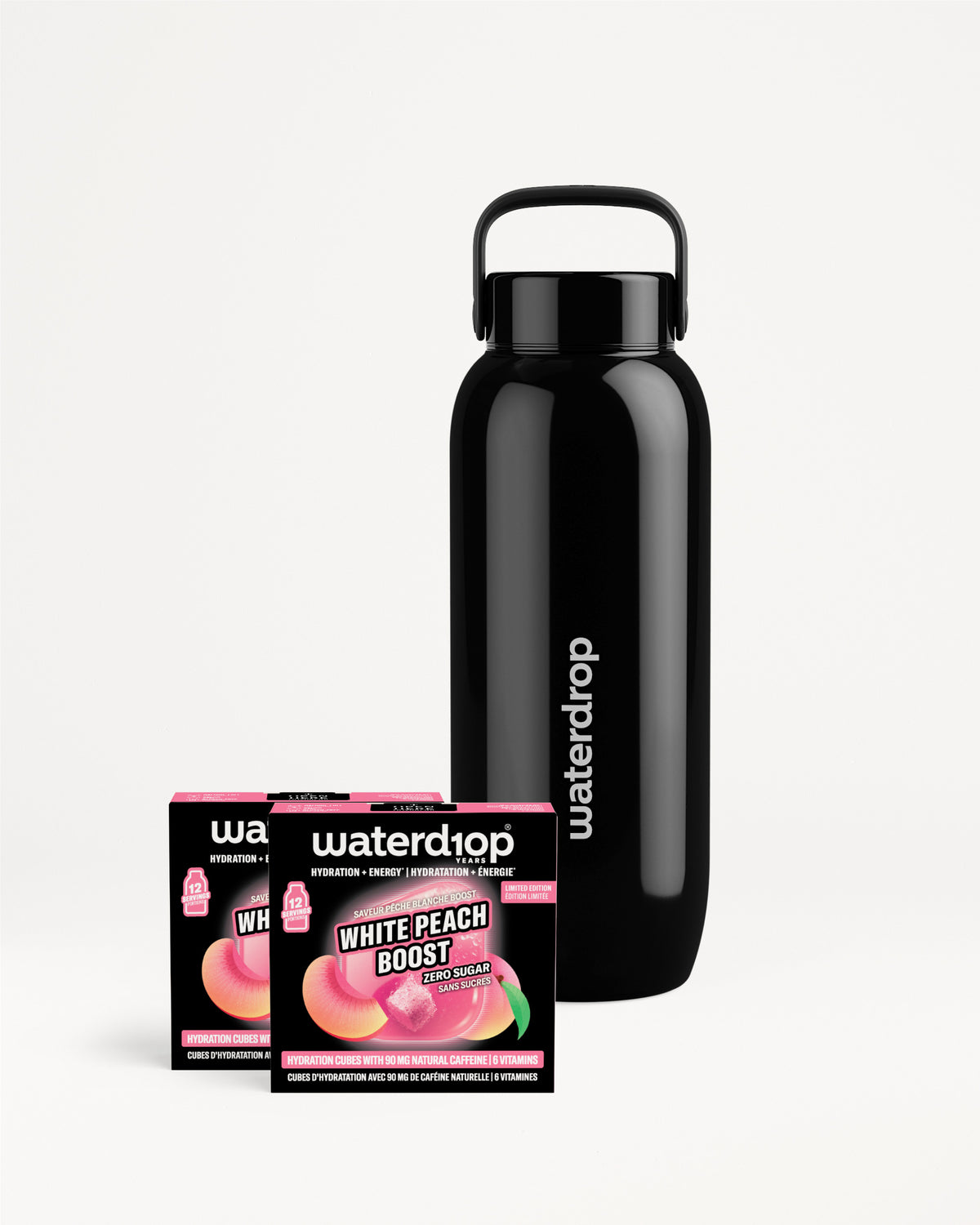 Bouteille réutilisable en acier inoxydable noire avec anse, accompagnée de deux petites boîtes de saveurs.