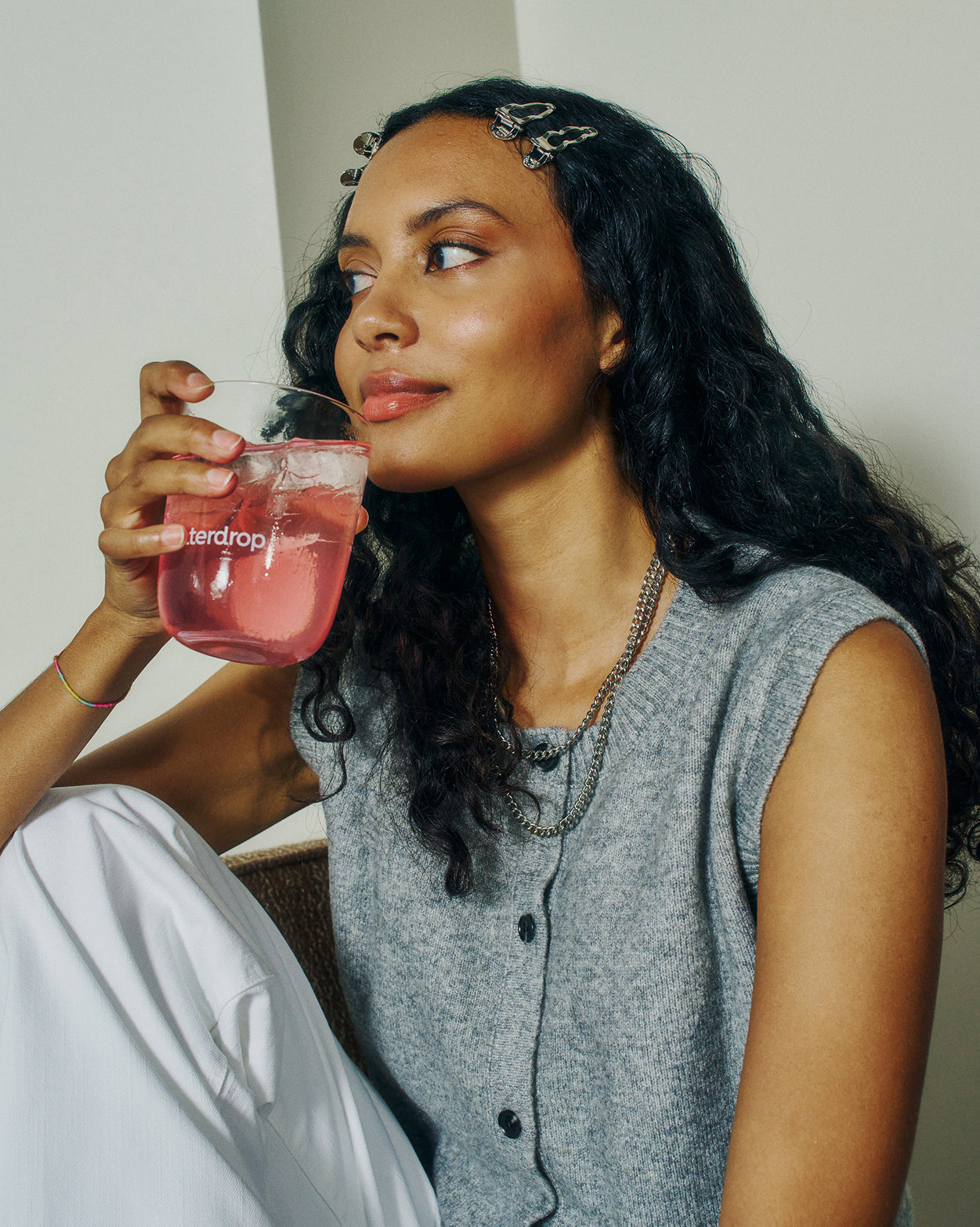 Woman sipping drink, showcasing Petit Calendrier de l'avent.