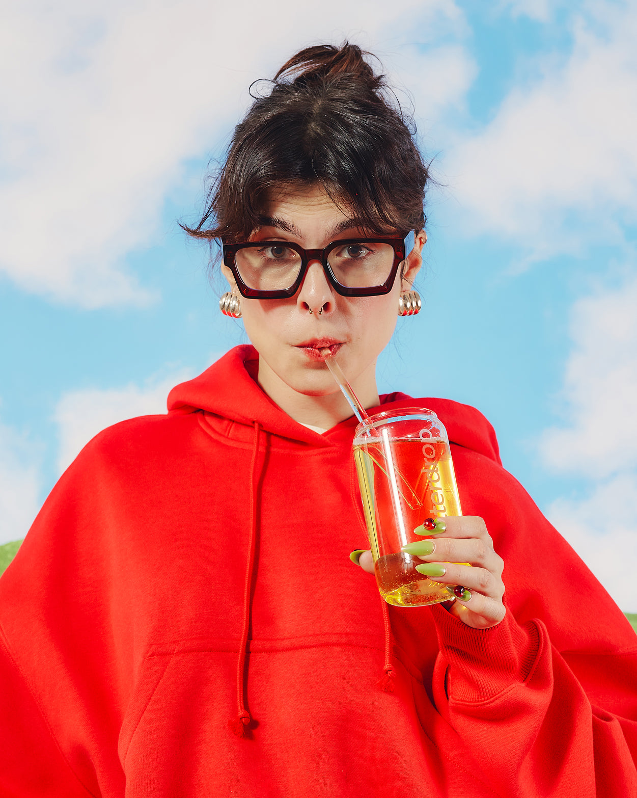 Young person sipping from Coffret Pomme pétillante glass.