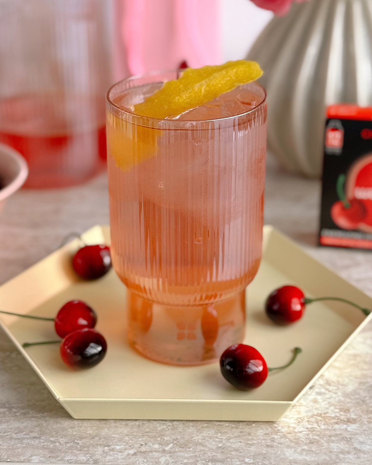 Coffret Spritz à la cerise with garnished glass and cherries.