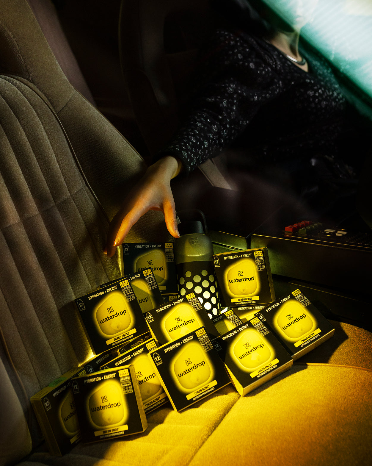 TURBO BOOST hydration cubes stacked with water bottle in car.