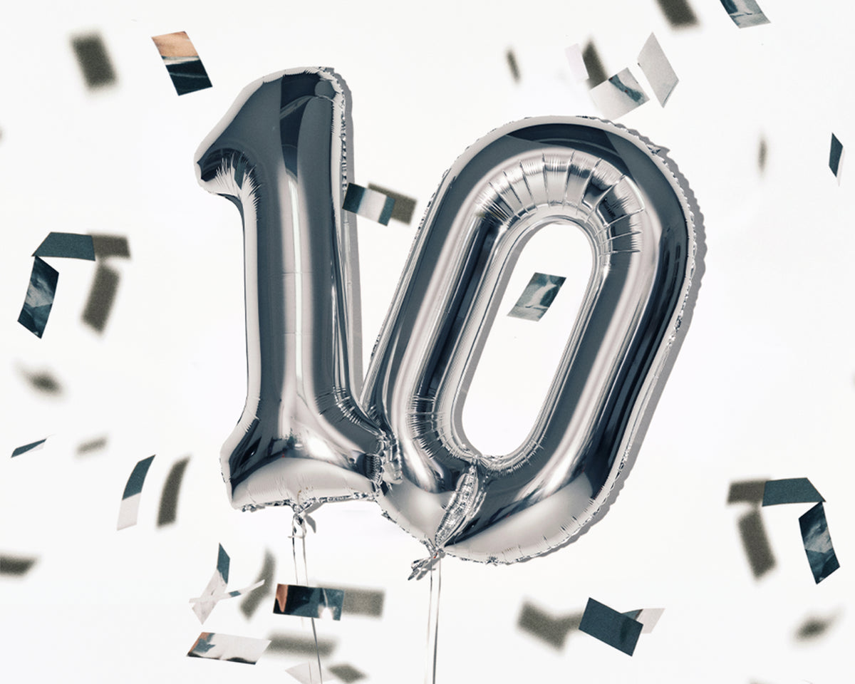 Ballons métallisés argentés en forme du chiffre 10 avec des confettis dispersés.