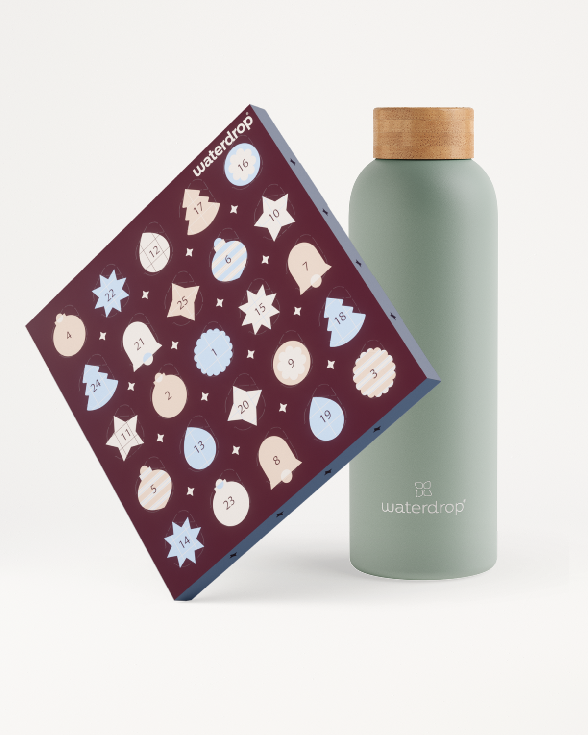 Boîte violette foncé inclinée avec de multiples icônes circulaires claires à côté d'une bouteille vert pâle avec bouchon en bois.