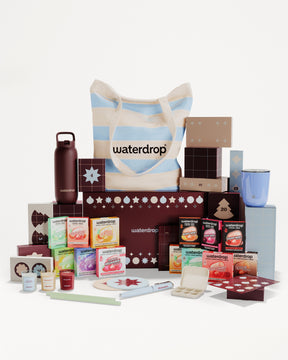 Ensemble cadeau composé de produits emballés et d’articles variés autour d’un sac à rayures.