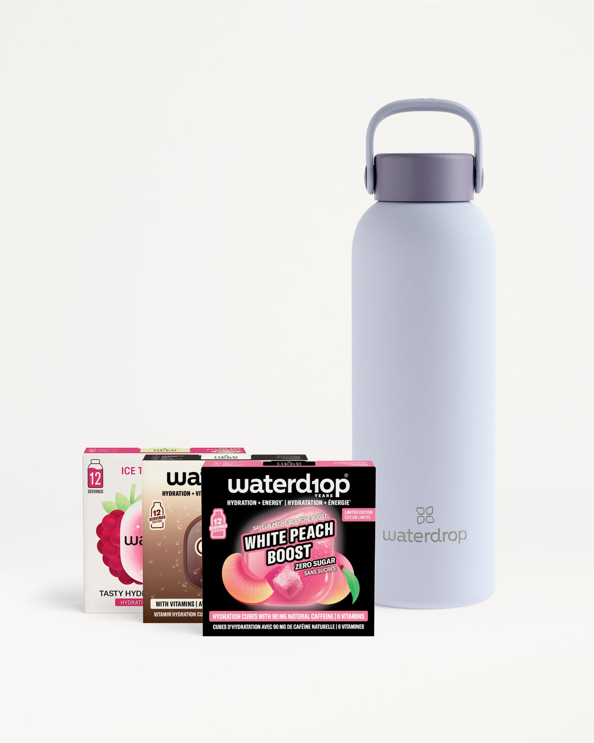 Bouteille d’eau réutilisable couleur lavande avec anse à côté de quatre sachets de saveur.