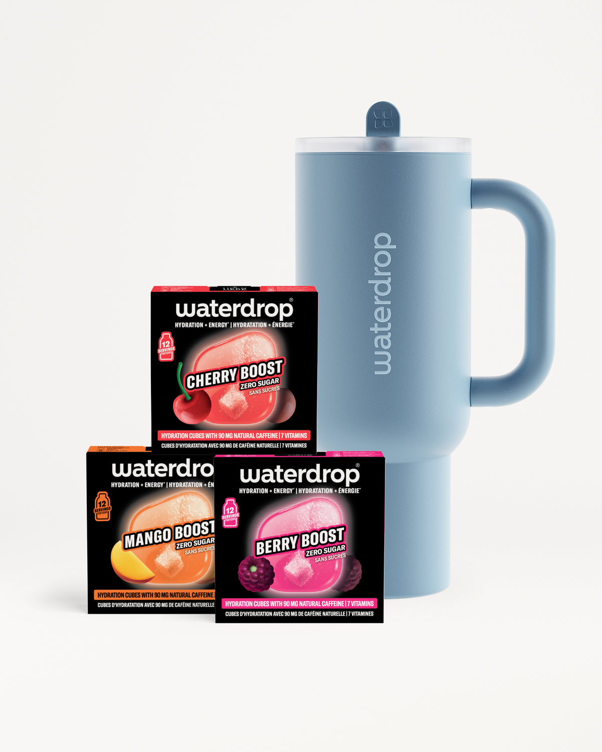 Mug isotherme bleu avec bouchon et poignée à côté de trois petites boîtes noires arborant des images colorées de fruits.