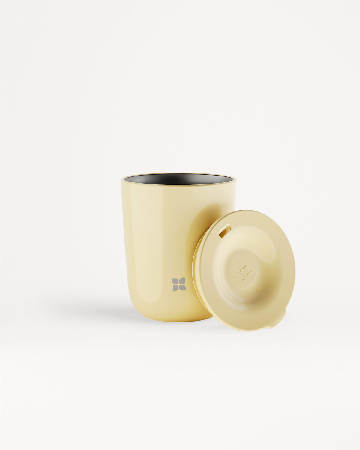Gobelet beige avec couvercle assorti posé à côté.