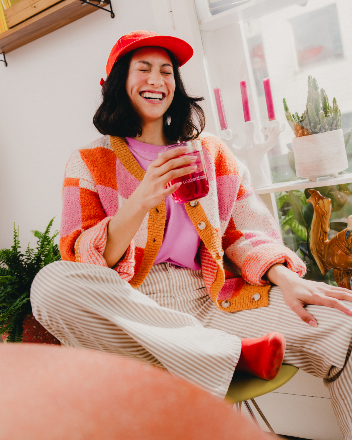 Double Pack HIBISCUS drink with smiling person indoors.