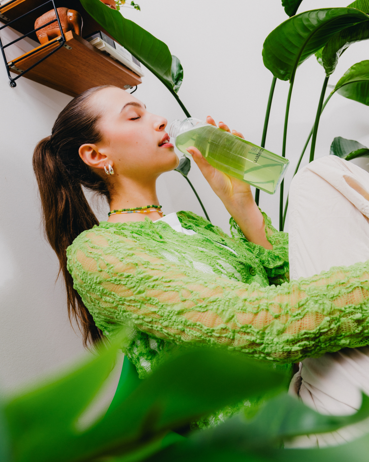 Woman enjoying Pack 1+1 Microdrink in plant-filled corner.